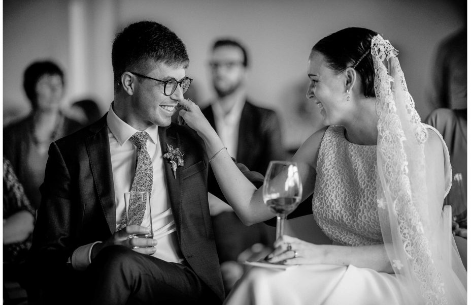 Bride in white lace wedding dress with lace veil smiles as she touches her smiling groom's face at Ponsonby Central Auckland wedding photo by Auckland wedding photographer Chris Loufte