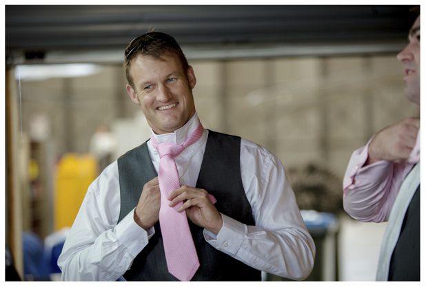 Groomsmen gets ready for a wedding knots his pink tie at Whenuapai airbase Kumeu.