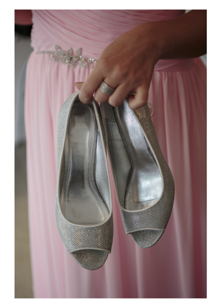 Close up photo of Bridesmaid's silver slip-on shoes against her pink pleeteddress