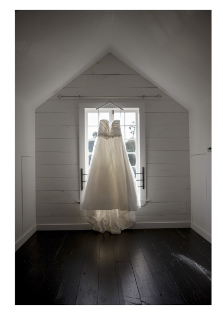 Full length wedding dress hangs in pretty sash window