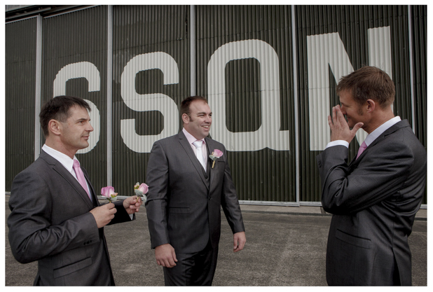 Groomsmen put on buttonhole flowers at Whenuapai airbase Kumeu.