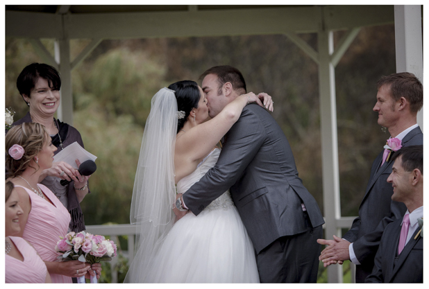 Bride and groom first kiss during wedding ceremony at Gracehill Vineyard Estate