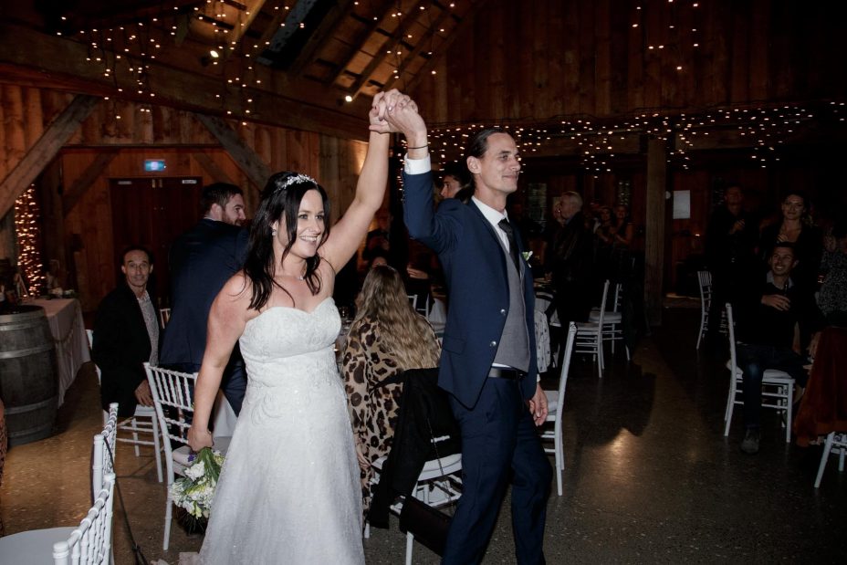 Brie and groom holding hands high enter wedding reception