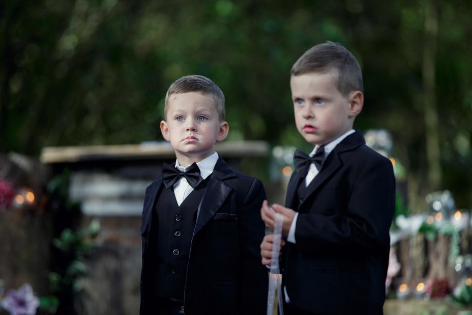 two young page boys in bow ties and black jackets at a wedding ceremony at Kumeu Valley Estate