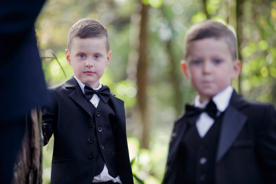 two young page boys in bow ties and black jackets at a wedding ceremony at Kumeu Valley Estate