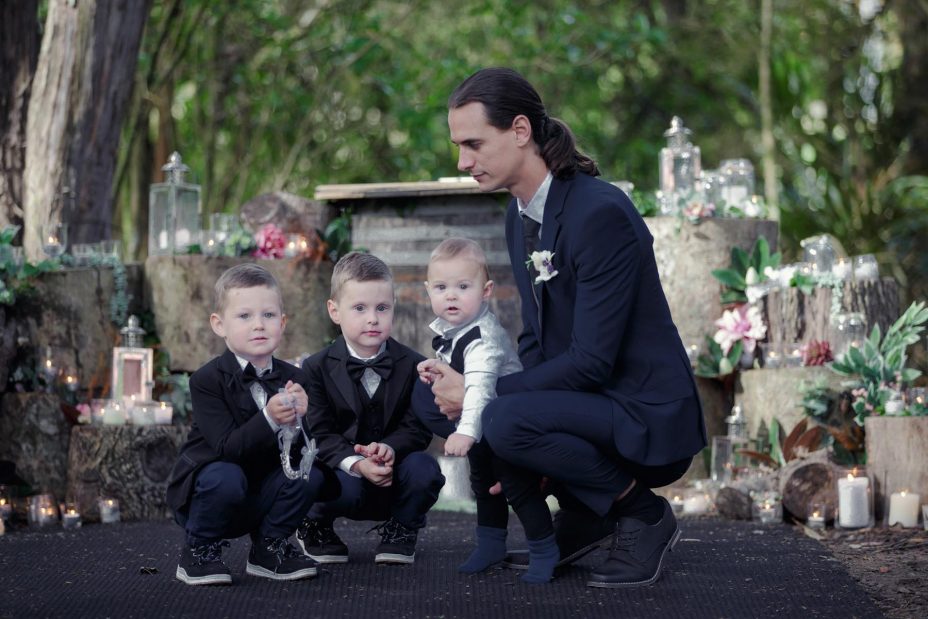 two young page boys and the groom wearing bow ties and black jackets at a wedding ceremony at Kumeu Valley Estate