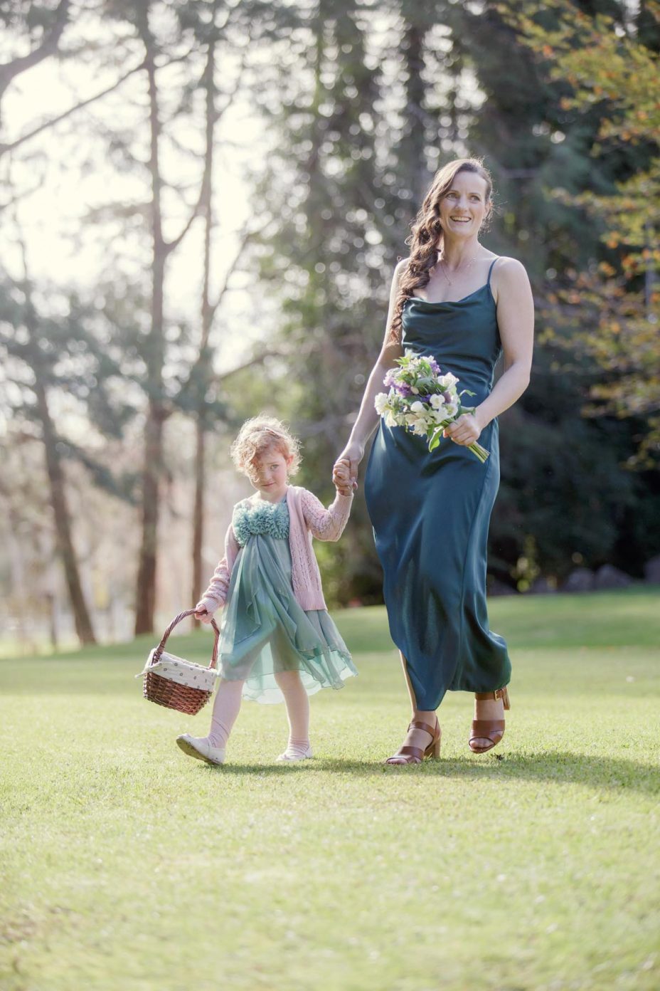Bridesmaid and flower girl with flower basket walk to the wedding ceremony