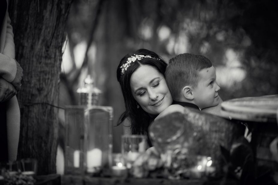 Bride cuddles little page boy at her wedding ceremony