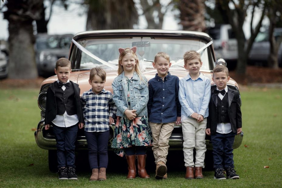 Children line up in front of American wedding car