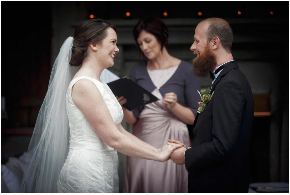 Bride and groom look into each other's eyes and smile during their wedding ceremony at Mantells Mount Eden.v