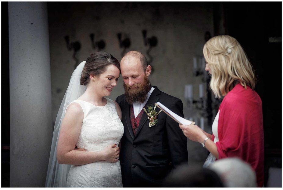 Bride and groom look into each other's eyes and smile during their wedding ceremony at Mantells Mount Eden.v