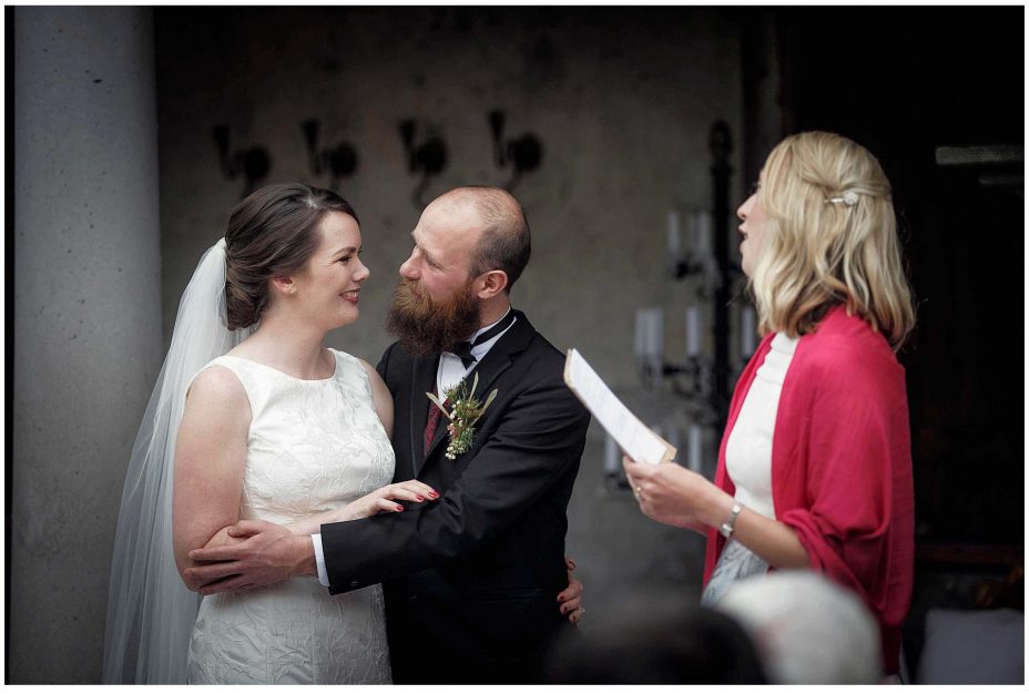Bride and groom look into each other's eyes and smile during their wedding ceremony at Mantells Mount Eden.v