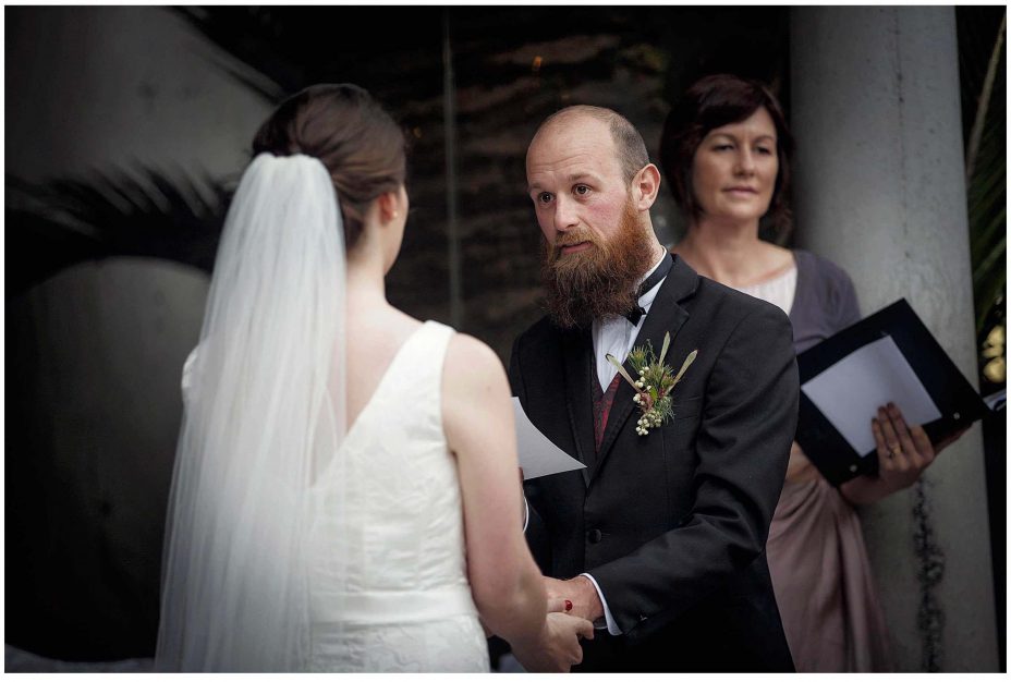 Bride and groom look into each other's eyes and smile during their wedding ceremony at Mantells Mount Eden.