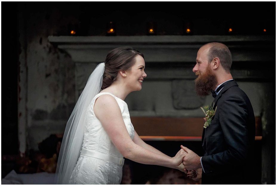 Bride and groom look into each other's eyes and smile during their wedding ceremony at Mantells Mount Eden.