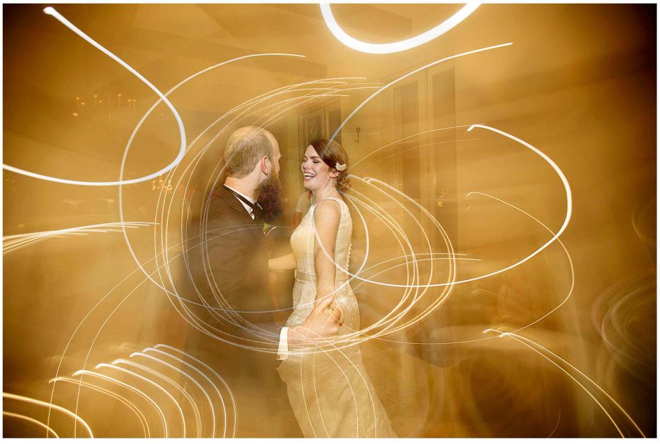 Bride and groom share their first wedding dance in a blaze of golden light. Mantells Mount Eden.