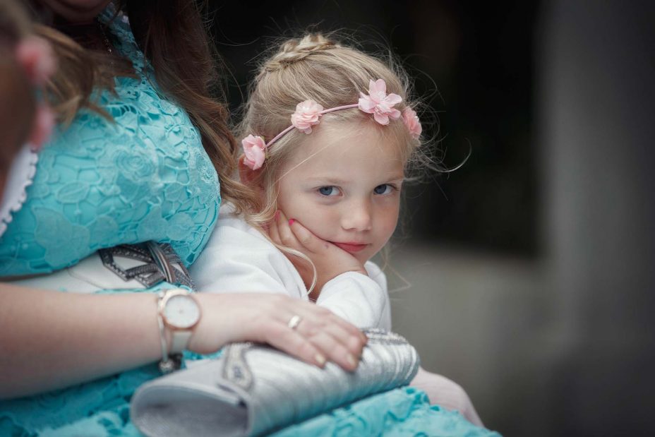 Cute flower girl wearing pink flower crown .
