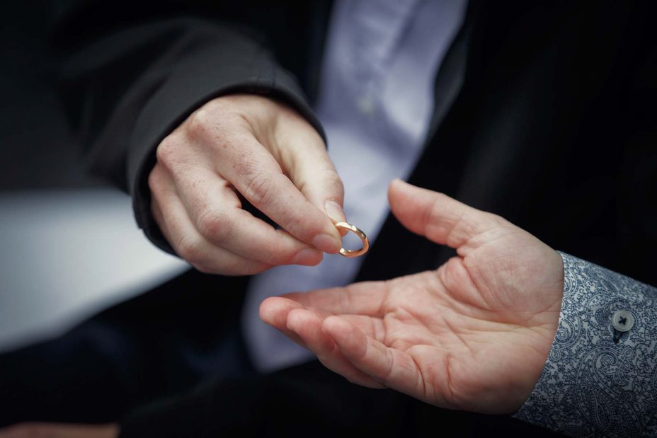 Bride's gold wedding ring is passed from hand to hand for all the wedding guests to hold at a ceremony at Mantells in Mount Eden.