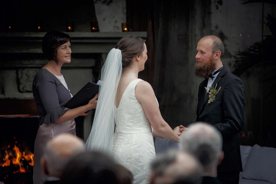 Bride and groom look into each other's eyes and smile during their wedding ceremony at Mantells Mount Eden.v