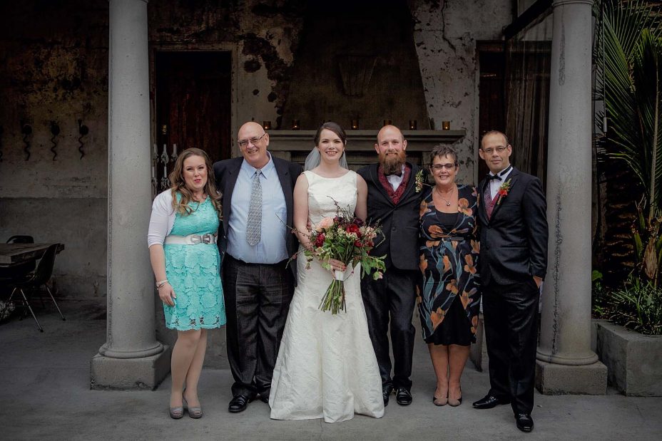 Bridal party group wedding photo infornt of the fireplace the ceremony at Mantells in Mount Eden.