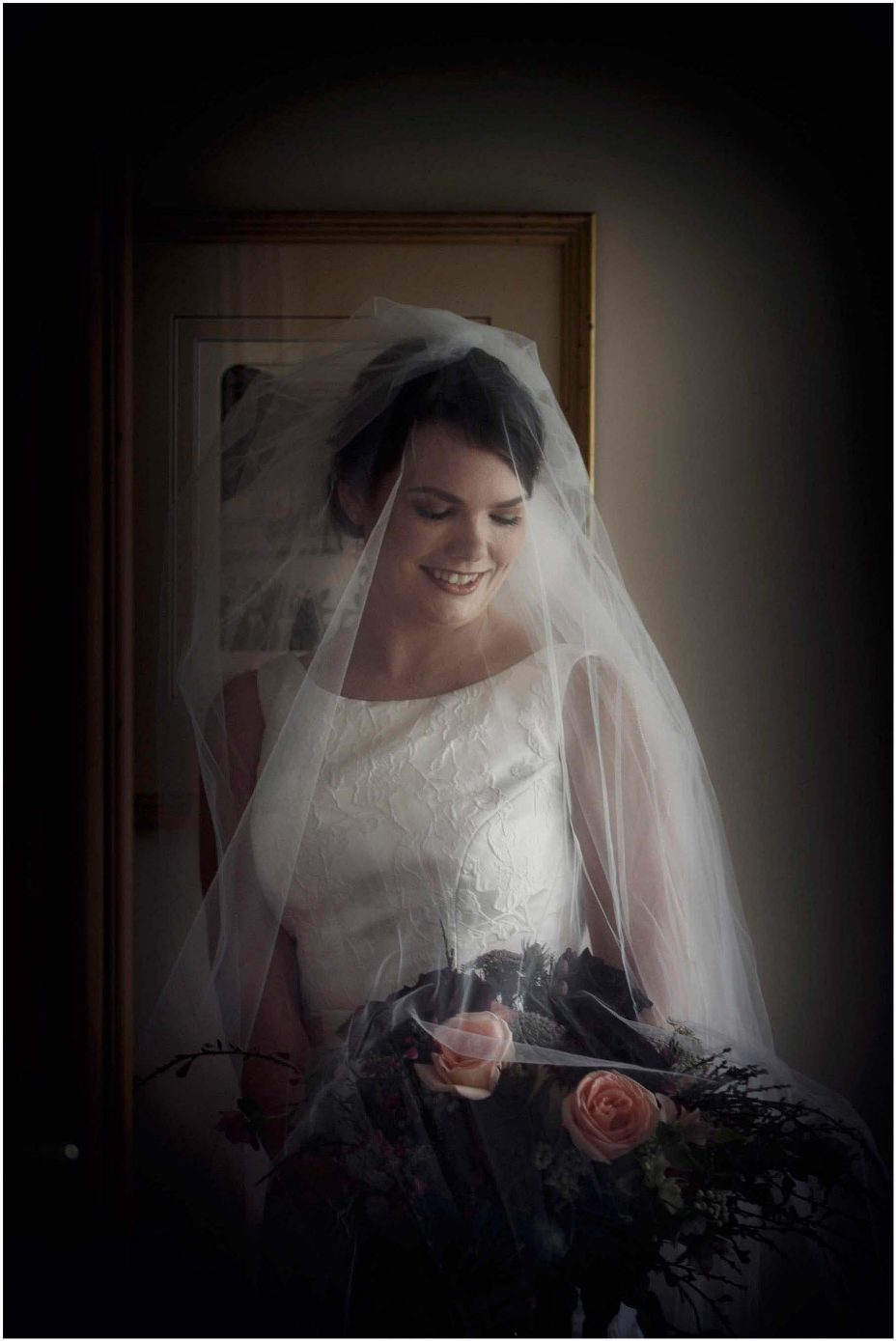 Bide wearing classical white wedding dress with train holding floral bouquet at Mount Eden Villa