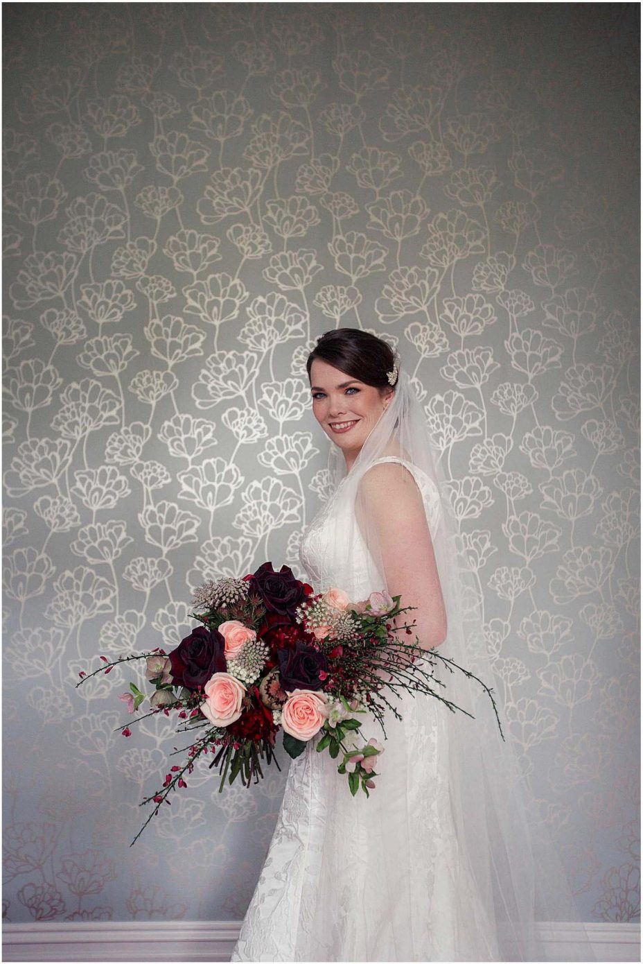 Bide wearing classical white wedding dress with train holding floral bouquet at Mount Eden Villa